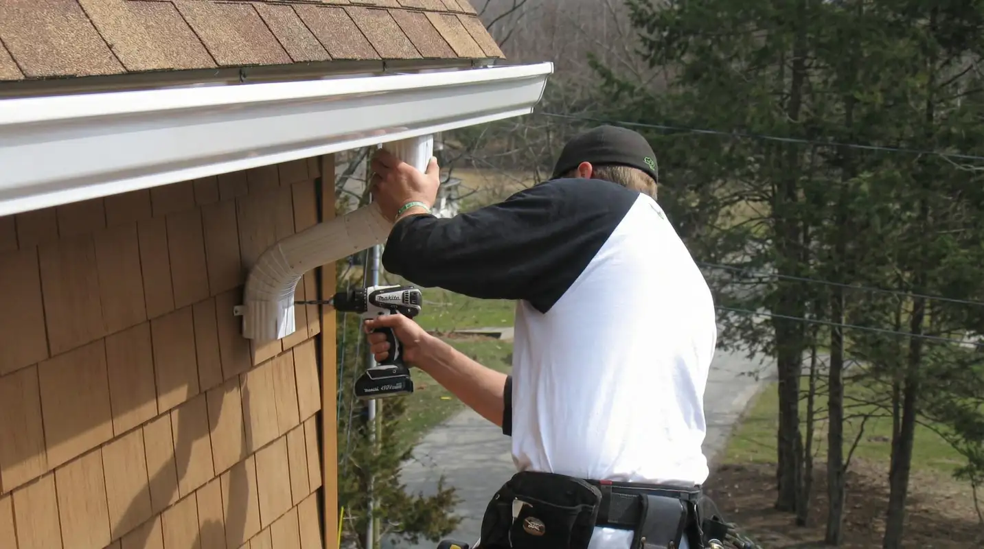 Professional contractor installing tan vinyl siding panels on a residential home exterior in Chicago, IL